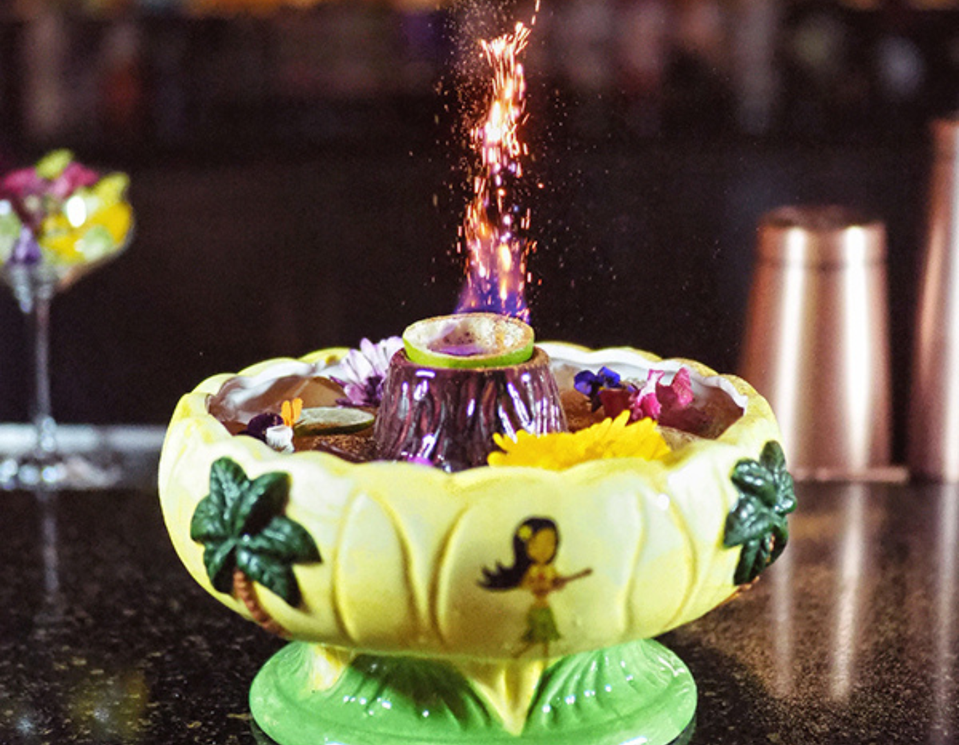 A photo of a tropical cocktail with fire coming out of the middle