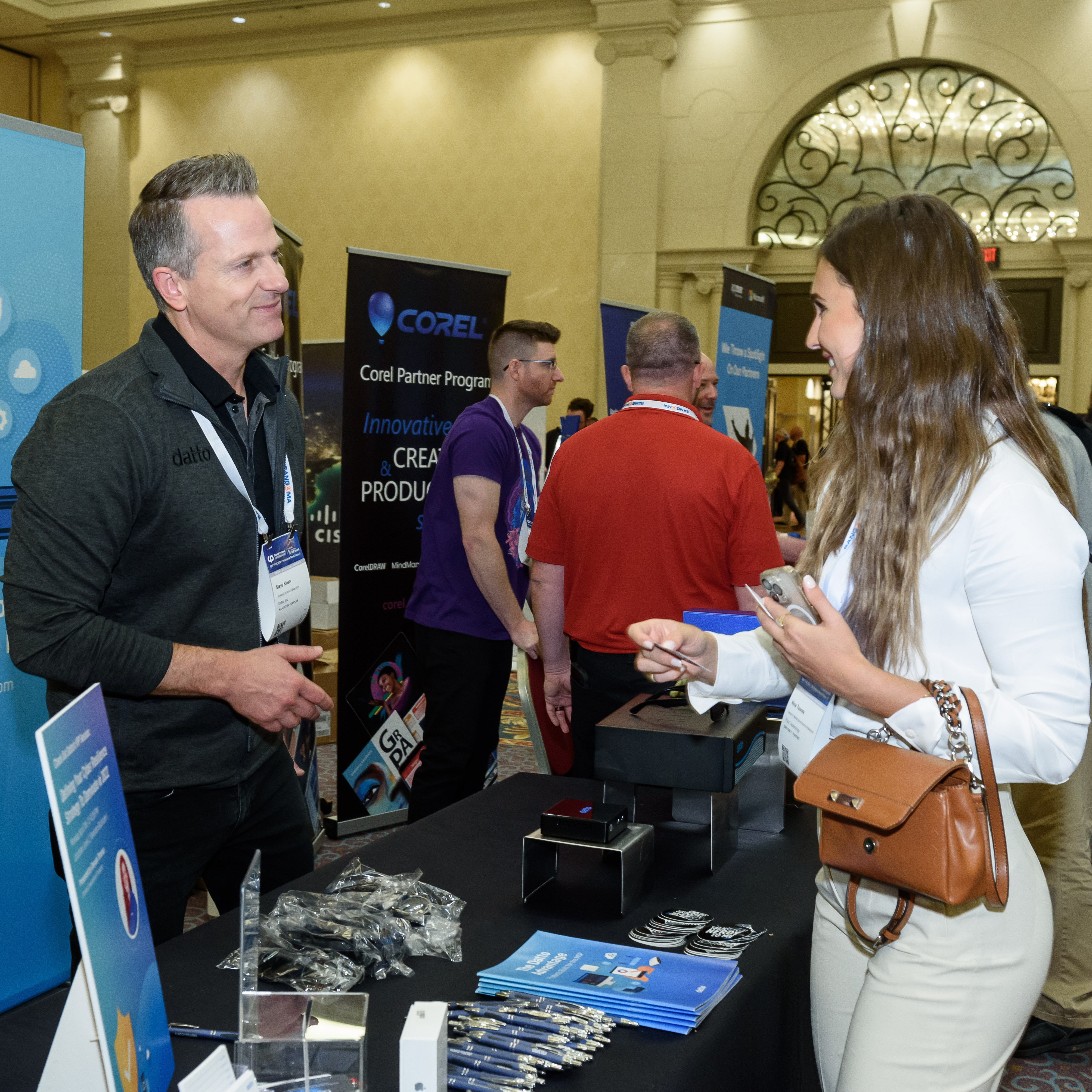 An exhibitor at the MSP Summit chats with a prospective customer in the expo hall