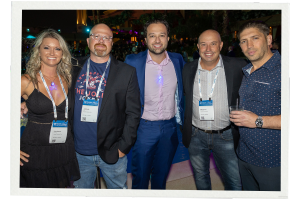 A photo of five people, four men and one woman, standing and smiling for the camera at a Channel Partners networking event.