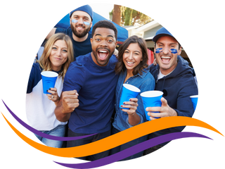 A photo of people wearing blue sports gear and holding blue plastic cups, celebrating at a sporting event. 